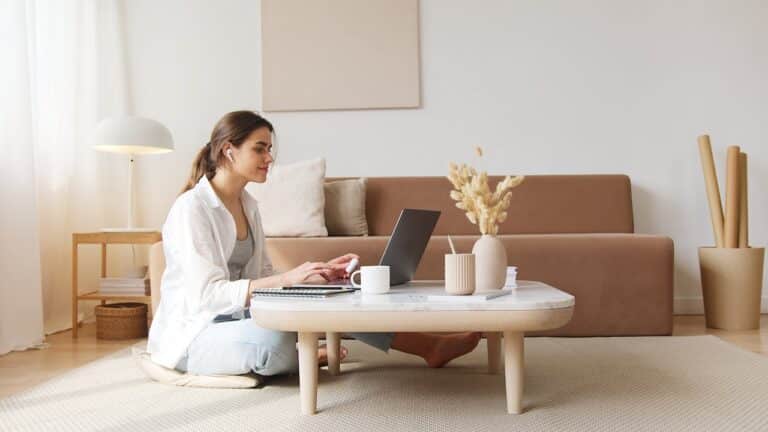 Woman attending an online therapy session from home using a laptop in a calm living space