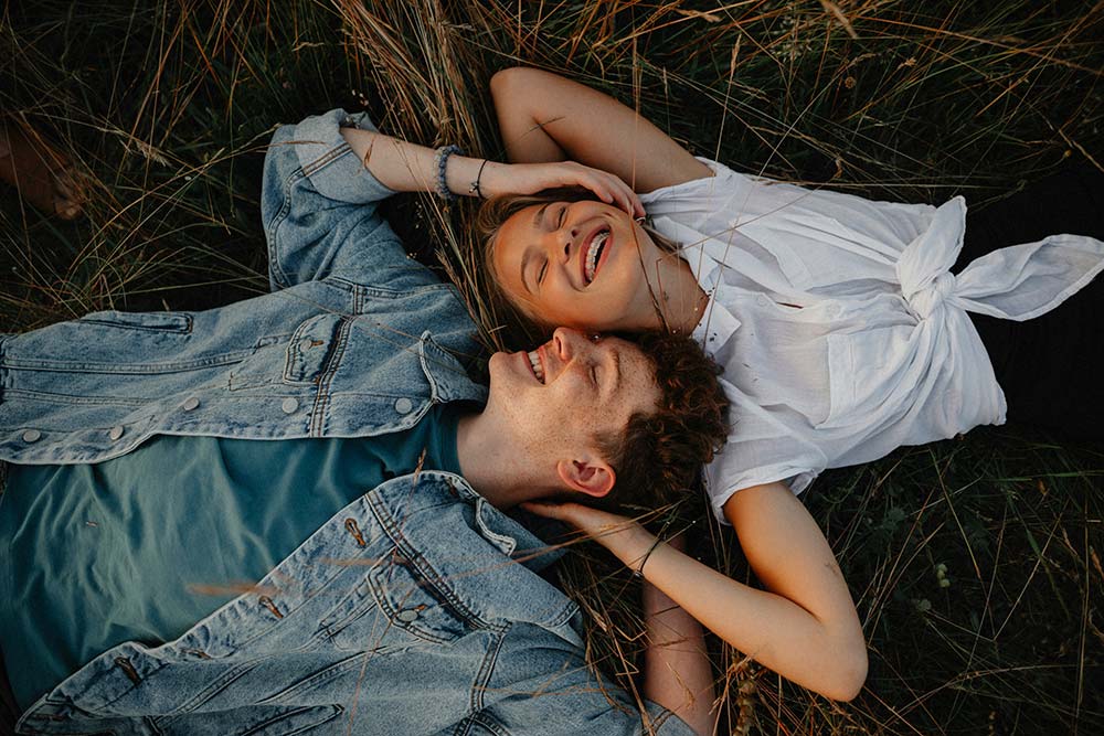 couple lying in the grass and laughing together.jpg