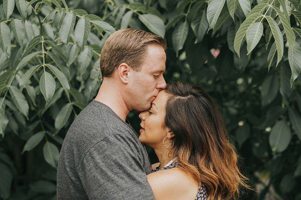 Couple hugging near a tree with leaves