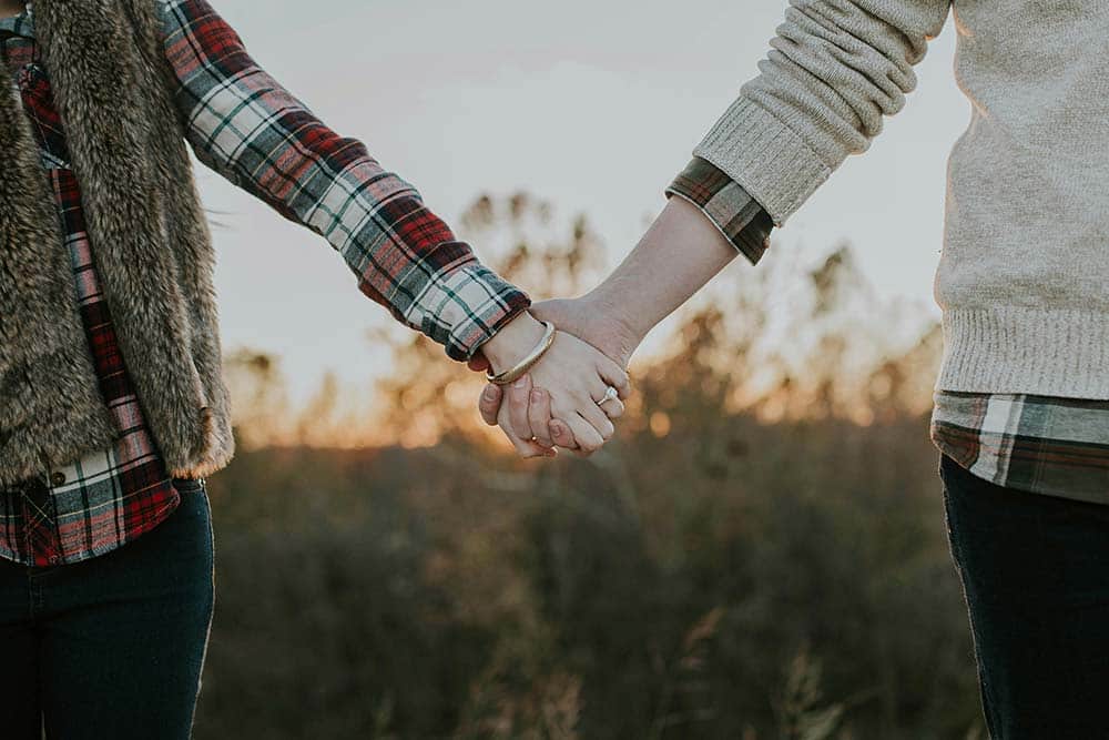 Two people holding hands while standing