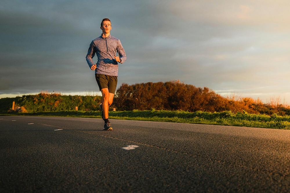 Man running down a road in the middle of the day